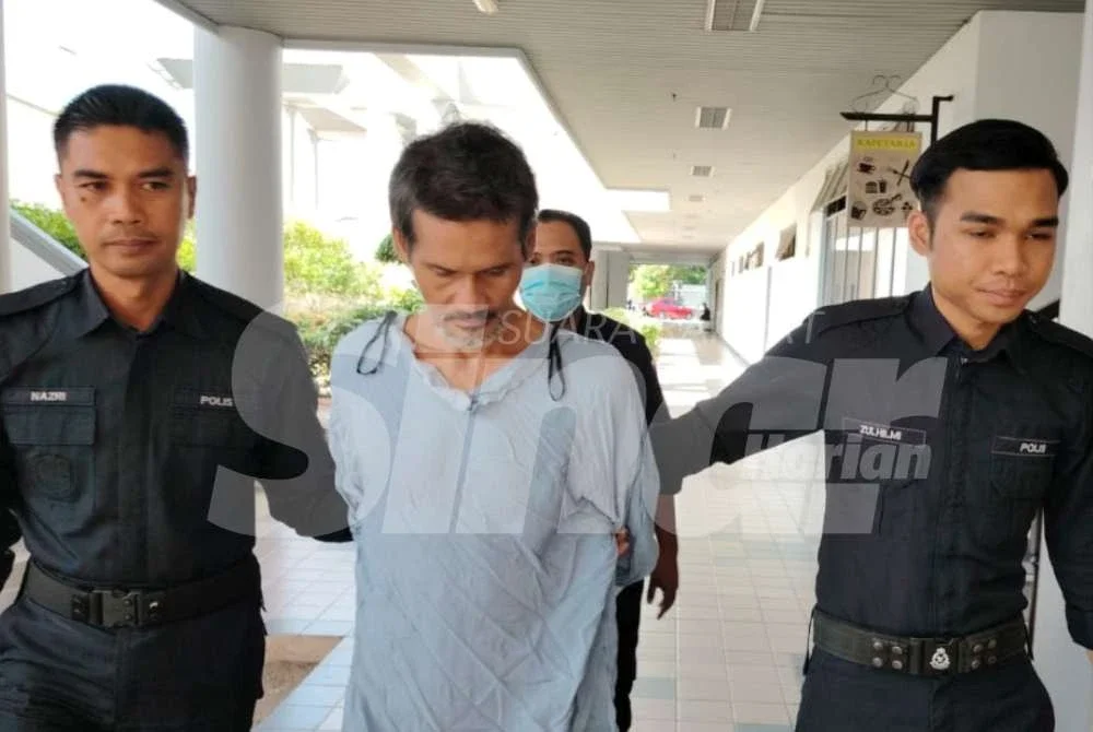 Tertuduh (tengah) dibawa keluar dari Mahkamah Majistret selepas selesai kertas pertuduhan dibacakan pada Rabu. 