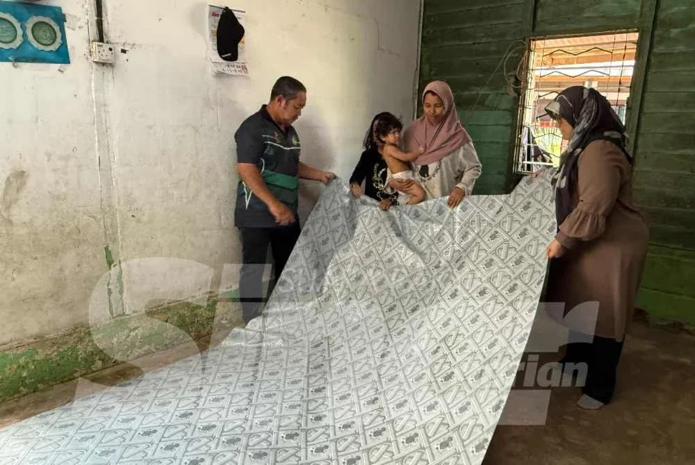 Kerja pemasangan tikar bagi memperindahkan rumah sewa didiami keluarga berkenaan. 