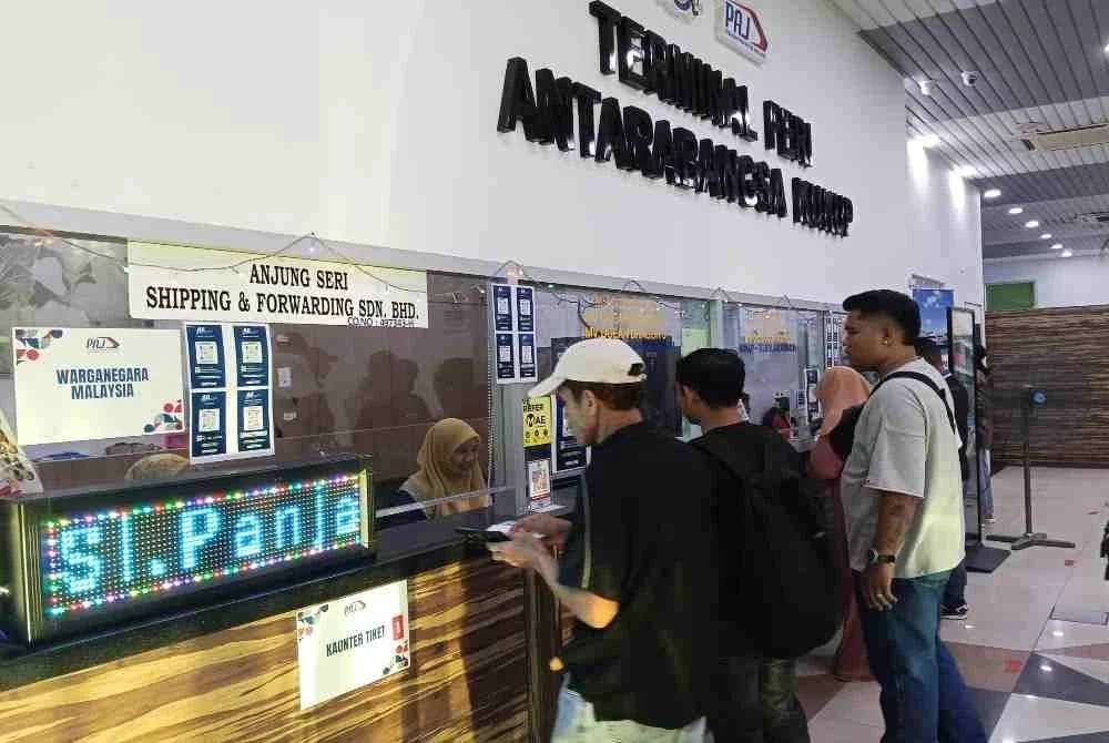 Suasana sibuk di kaunter tiket Kukup ketika perantau Indonesia bersiap pulang ke kampung.