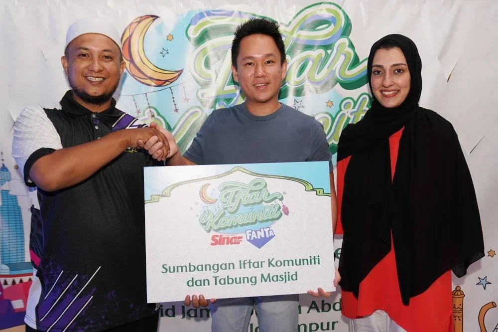 Simbolik penyerahan Mock Cheque sumbangan Iftar Komuniti dan Tabung Masjid daripada Cola-Cola Malaysia kepada Masjid Jamek Sultan Abdul Samad yang diwakili Mohd Hariz (kiri) sempena program iftar berkenaan anjuran syarikat minuman multinasional itu dan Sinar Harian pada Ahad.