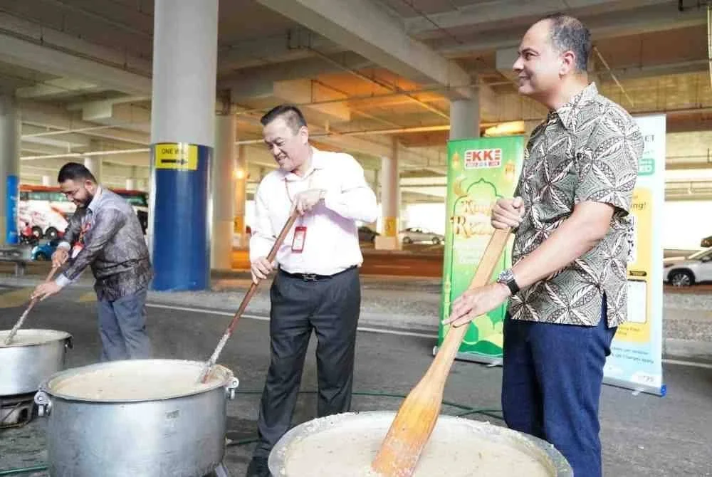 KK Chai (tengah) mengambil peluang mengacau bubur lambuk untuk diagihkan kepada penumpang Terminal Bersepadu Selatan. Turut bersama Ketua Pegawai Eksekutif TMAS Sdn Bhd, Shazwan Mohammad (kanan).
