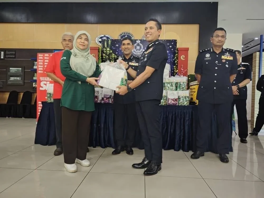Rosnani (kiri) menyerahkan pek makanan kepada Ketua Jabatan Pengurusan Selangor, SAC Mohd Iqbal Ibrahim dengan disaksikan Timbalan Ketua Polis Selangor, DCP Mohd Zaini Abu Hassan (tengah).