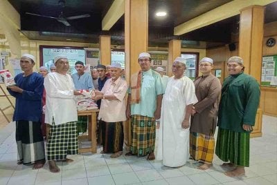 Sabri (dua dari kiri) menyerahkan tepung gandum kepada kariah Masjid Ar Rahman Kerpan.
