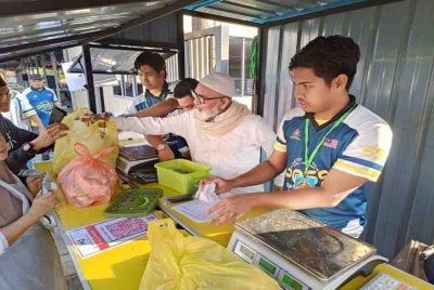 Syed Abu Hussin (dua dari kanan) yang juga Ketua Kluster Makanan Majlis Tindakan Kos Sara Hidup (NACCOL) turut membantu melancarkan operasi Jualan Murah Pusat Khidmat Parlimen Bukit Gantang, pada Rabu.