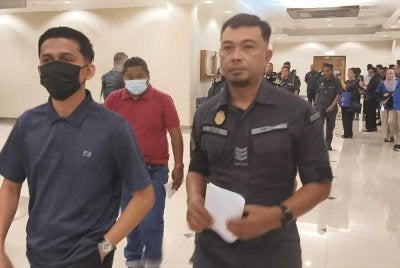 Pegawai SWCorp mengiringi dua daripada tiga individu yang didakwa atas kesalahan di bawah Akta 672 keluar dari mahkamah selepas mengaku bersalah dan dijatuhkan hukuman pada Rabu.