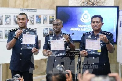 Kumar (tengah) menunjukkan geran kenderaan klon yang dirampas JSJ dalam operasi khas baru-baru ini. Foto: SINAR HARIAN/ROSLI TALIB