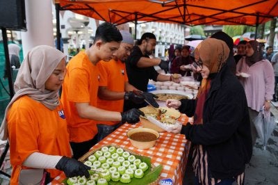 Sukarelawan Cola-Cola Malaysia menyiapkan juadah sempena Program Iftar Komuniti yang dianjurkan oleh Coca-Cola Malaysia dan Sinar Harian yang diadakan di Masjid Jamek Sultan Abdul Samad pada Ahad.