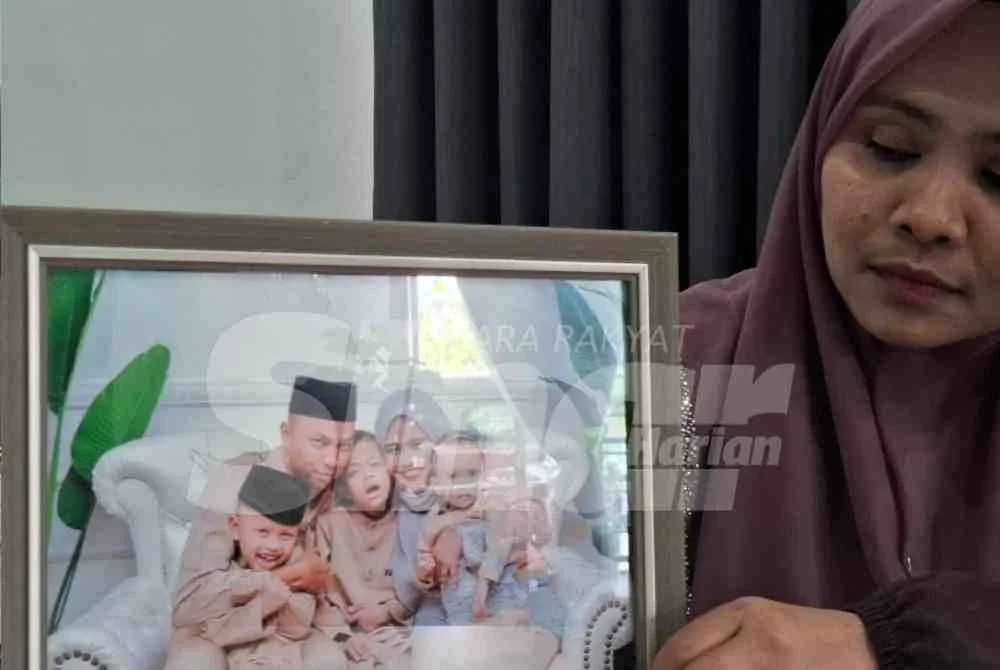 Nur Aini melihat potret kenangan mereka sekeluarga yang dirakam sekitar empat tahun lalu.