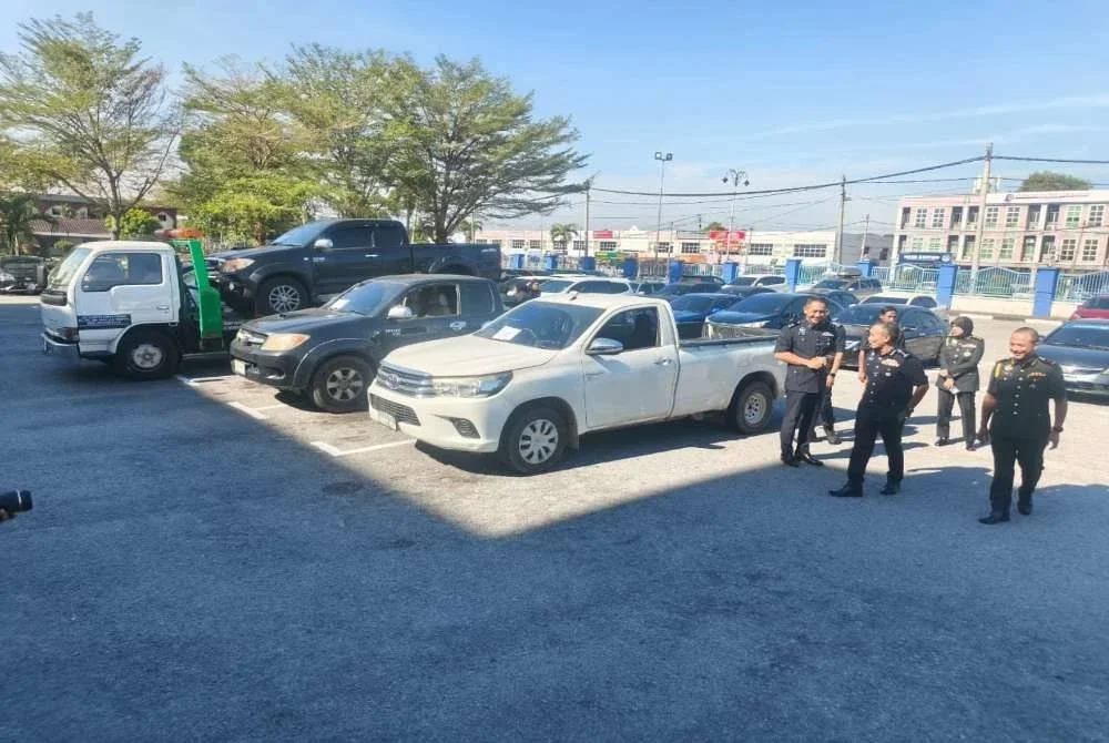 Adzli (dua kanan) melihat lima pikap yang ditahan cuba menyeludup 2,000 liter petrol di Bukit Kayu Hitam pada Rabu. 