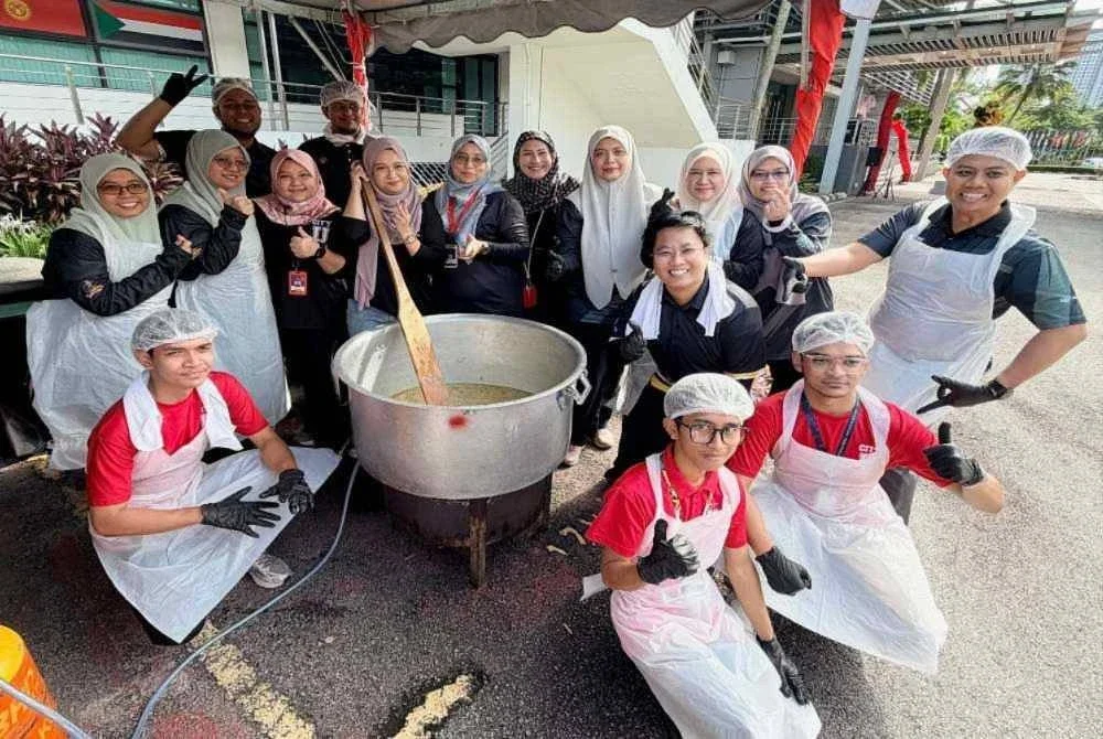 Pengarah Negeri Pejabat PTPTN Negeri Selangor, Rohaida Deris (tiga dari kanan) dan kakitangan PTPTN bersama pelajar City Universiti, Cyberjaya bergotong royong menyediakan juadah bubur lambuk.