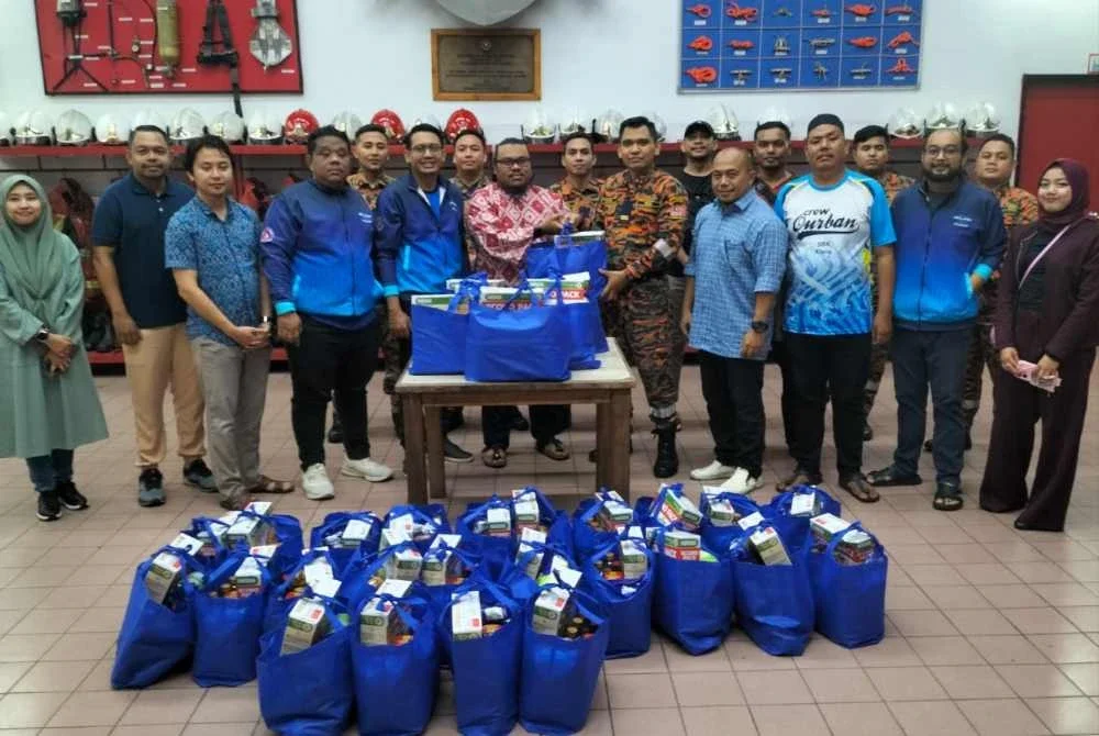 Izzat menyampaikan pek makanan tajaan Nestle kepada Pegawai Bomba Kanan II, Balai Bomba Seksyen 17, Syafiq Mohd Shukri.