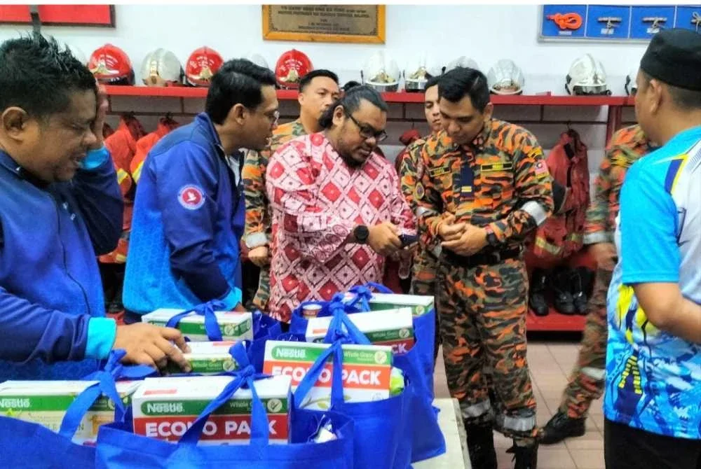 Izzat beramah mesra dengan Pegawai Bomba Kanan II, Balai Bomba Seksyen 17, Syafiq Mohd Shukri.