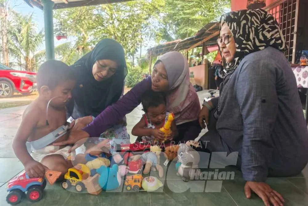 Fatin Nur Atiqah (dua dari kanan) menunjukkan kesan pembedahan pada perut Ammar kepada Zuraini (dua dari kiri).
