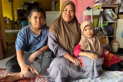 Mohd Syakir (kiri) yang belum mempunyai baju raya bersama Nur Zawahir (tengah) dan Nurul Safura Nazihah (kanan).
