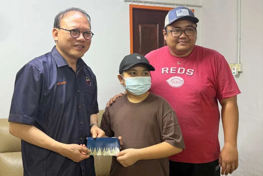 Unit medikal PSBM, Dr Khor Ying Kim menyampaikan sumbangan kepada Isaac dan Faizal ketika mengunjungi keluarga itu baru-baru ini.