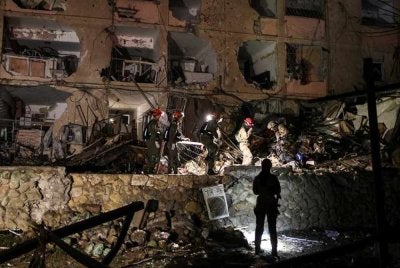 Anggota tentera Israel mencari mangsa di bawah runtuhan bangunan selepas serangan peluru berpandu Iran mengenai Dimona, ketika konflik AS‑Israel dengan Iran berlanjutan di selatan Israel. - Foto Reuters