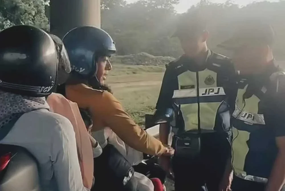 Anggota JPJ SPK Kalumpang ketika membantu sebuah keluarga kecil yang berdepan kesukaran ketika hujan di Lebuhraya Utara-Selatan, Khamis lalu. Foto JPJ Selangor