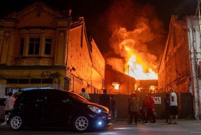 Anggota bomba berusaha memadam kebakaran sebuah kedai buku dua tingkat di Jalan Datuk Syeh Ahmad, Seremban pada Ahad. - FOTO: Bernama