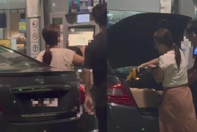 Tangkap layar video tular memaparkan seorang lelaki dan wanita mengisi RON95 ke dalam tong di but kereta.