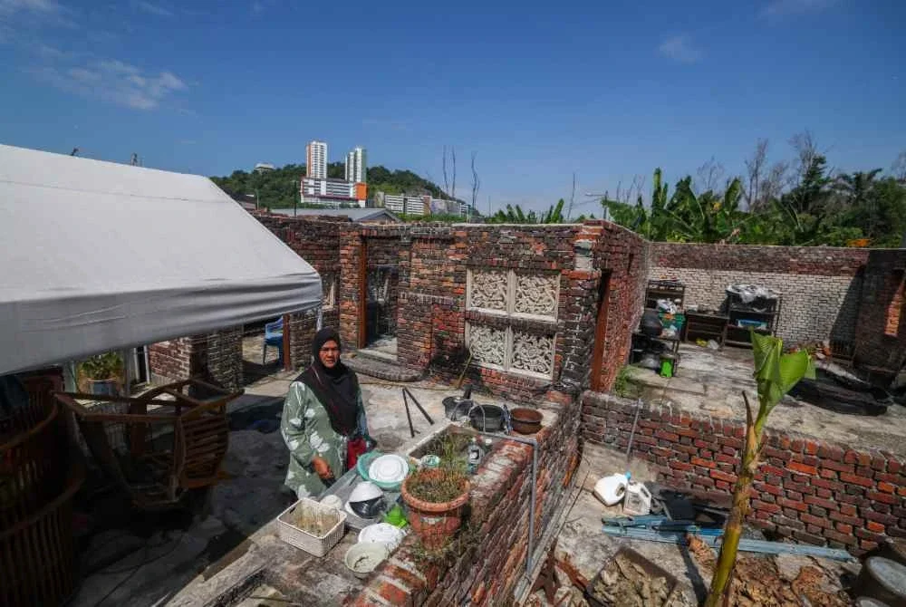 Aliyah di dalam rumahnya yang musnah akibat tragedi letupan gas di Taman Putra Harmoni tahun lepas, ketika ditemui di Kampung Kuala Sungai Baru. Foto Bernama