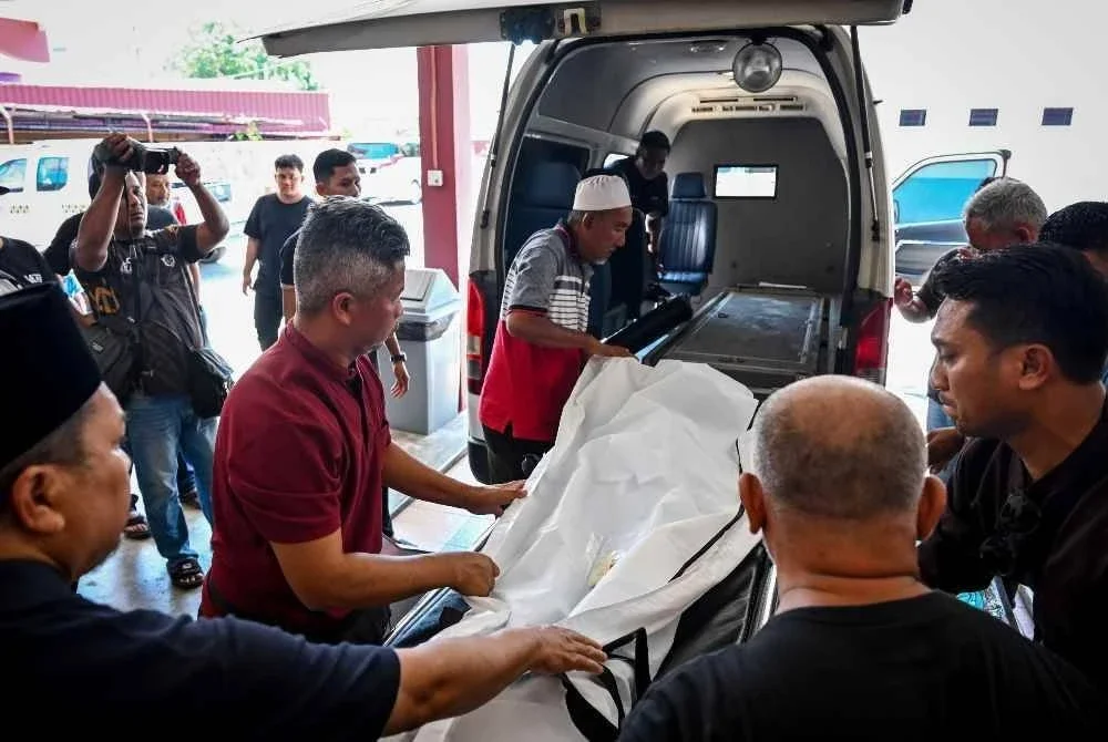 Mohamad Redzuan Abdullah, 40 (dua kiri) bersama ahli keluarga menguruskan jenazah isterinya Allahyarham Nurul Hafizah Shaary, 39, dan kedua anaknya, Mohd Redzuan Arash Mohd Redzuan,13, Nur Radya Athalia, 4, ketika ditemui di Jabatan Perubatan Forensik Hospital Sultanah Nur Zahirah (HSNZ) hari ini. Foto Bernama. 