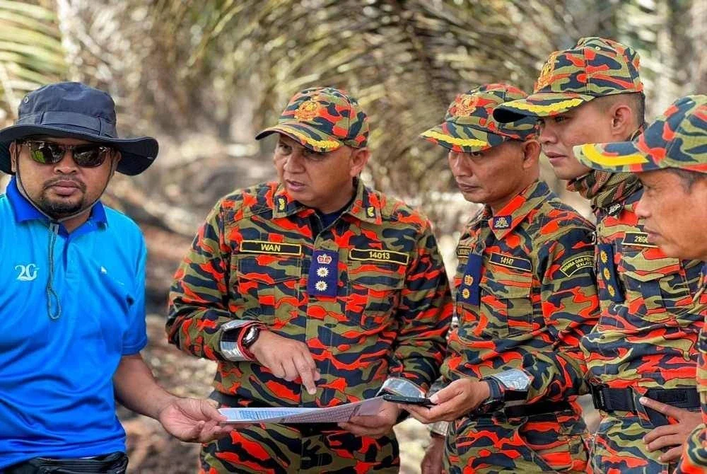 Wan Ahmad Fadillah (dua dari kini) sedang meninjau keadaan kebakaran pada Selasa. FOTO: Bomba Pahang.