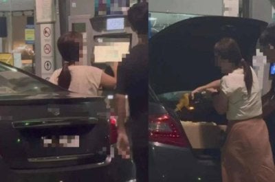 Tangkap layar video tular memaparkan seorang lelaki dan wanita mengisi RON95 ke dalam tong di but kereta.