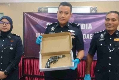 Tengku Mohd Faisal (tengah) menunjukkan pistol jenis Revolver yang dirampas.