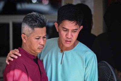 Mohamad Redzuan Abdullah, 40 (kiri) kelihatan hiba selepas isterinya, Nurul Hafizah Shaary, 39, dan kedua anaknya, Mohd Redzuan Arash Mohd Redzuan,13, Nur Radya Athalia, 4, maut selepas kenderaan utiliti sukan (SUV) yang dinaiki mereka terlibat dalam kemalangan di Kilometer 59, Jalan Jerangau-Jabor berhampiran Felda Jerangau, di sini semalam. Foto Bernama 