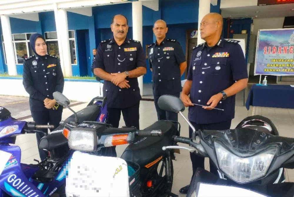 Hanyan (kanan) menunjukkan motosikal yang dirampas dalam Op Lejang.