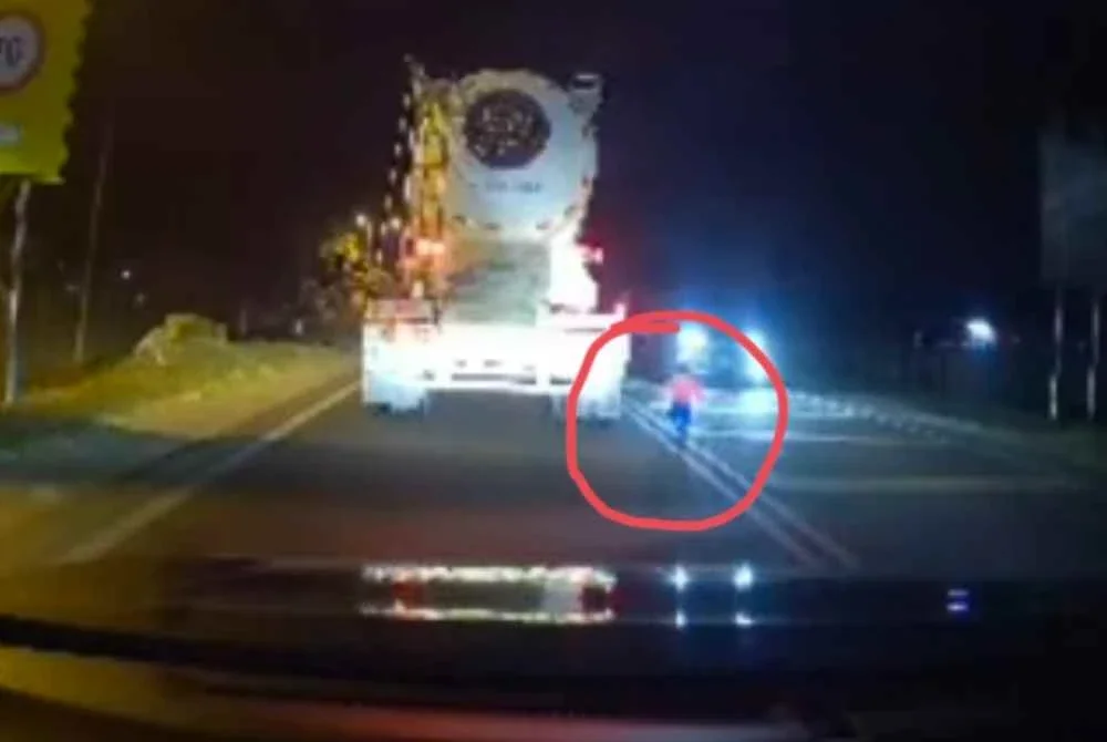 Tangkap layar video tular memaparkan seorang kanak-kanak berlari ke tengah jalan raya pada waktu malam di Jalan Terachi, Kuala Pilah