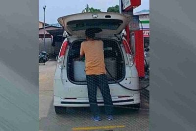 Tangkap layar rakaman 'dashboard' memaparkan seorang individu mengisi petrol RON95 ke dalam tong di sebuah stesen minyak tular di media sosial.