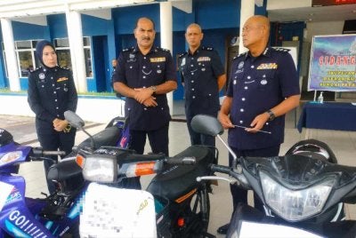 Hanyan (kanan) menunjukkan motosikal yang dirampas dalam Op Lejang.