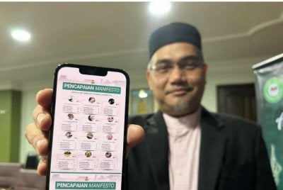 Mohd Asri menunjukkan data pencapaian manifesto di telefon bimbitnya