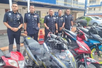 Mohamad Lazim (tengah) menunjukkan motosikal yang dicuri kumpulan penjenayah.