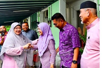 Rohani (kiri) melayan tetamu yang hadir pada Majlis Sambutan Hari Raya Aidilfitri Parlimen Kota Bharu Peringkat Dewan Undangan Negeri (DUN) Tanjong Mas di Kota Bharu pada Khamis. 