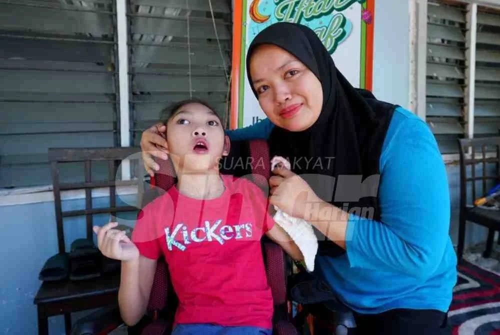 Noor Aishah bersama anaknya, Dian Maidarah, 10, yang terlantar akibat Cerebral Palsy (CP).