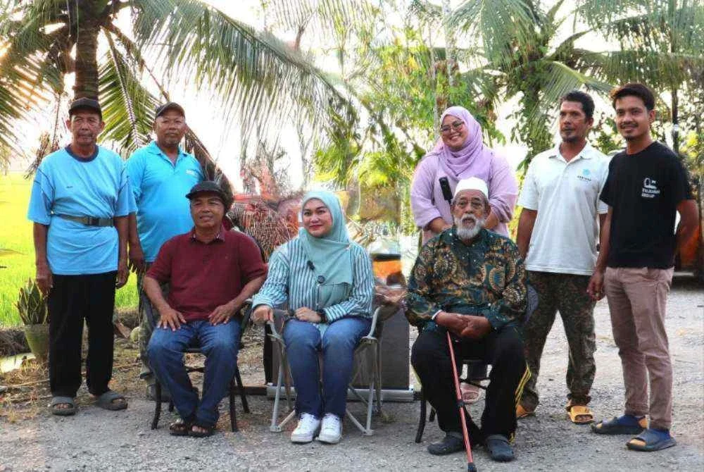 Nurul Syazwani (duduk tengah) semasa menziarahi golongan pesawah yang terkesan akibat kenaikan harga diesel dan cuaca panas yang melanda negara ketika ini.