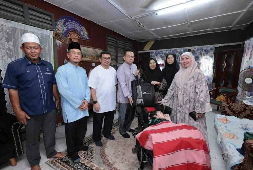 Pengerusi Surau TH, Mohd Norber Kassim (empat dari kiri) menyerahkan kotak infaq yang mengandungi barangan keperluan asas kepada salah satu penerima bagi Program Serahan Barangan Kempen Infaq Ramadan pada awal bulan ini di Kampung Awah, Maran, Pahang.
