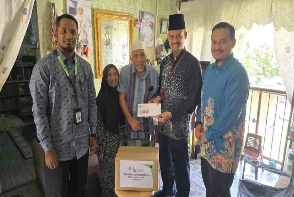 Ketua Cawangan Pemerkasaan Sahsiah, Jabatan Modal Insan TH, Shahrul Azam (dua dari kanan) menyerahkan sumbangan tunai dan kotak infaq kepada bekas pengajar Al-Quran, Zahari Ismail di Flat Sri Perlis, Jalan Datuk Keramat, Kuala Lumpur.