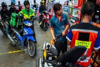 Penunggang motosikal beratur untuk mengisi minyak di sebuah stesen petrol di tengah konflik Amerika Syarikat-Israel dengan Iran, di Bangkok, Thailand, pada Khamis. - Gambar Reuters