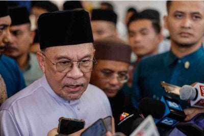 Anwar bercakap kepada pengamal media selepas menunaikan solat Jumaat di Masjid Tengku Ampuan Jemaah, Bukit Jelutong, pada Jumaat. Foto Bernama