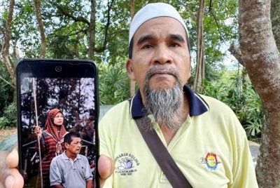 Rakan mangsa, Hashim Abdul Aziz, 66 menunjukkan gambar mangsa, Zikri Abdul Rahman, 65 dan pasangannya Suraya Man, 53 dipercayai dibunuh di rumah mereka di Kampung Balau, Merbok. Foto Bernama. 