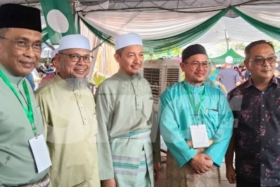 Takiyuddin (kiri) bergambar bersama tetamu yang menghadiri Rumah Terbuka Aidilfitri Pas Kelantan di Dataran Warisan Stadium Sultan Muhammad IV, Kota Bharu pada Sabtu. Foto: HAZELEN LIANA KAMARUDIN