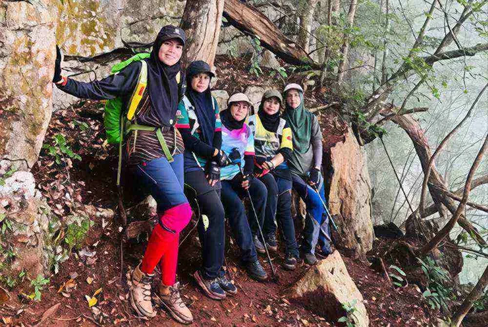 Nurul Ashikin bersama pendaki dibawanya bergambar di satu laluan trek Gunung Senyum di tepi gua batu kapur - Foto: Nurul Ashikin