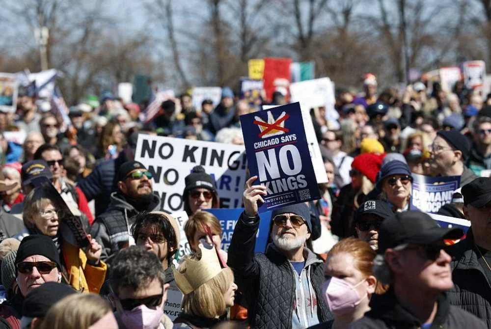 Orang ramai memegang sepanduk ketika berhimpun di Grant Park sempena perhimpunan 'No Kings' di Chicago pada Sabtu. Foto AFP