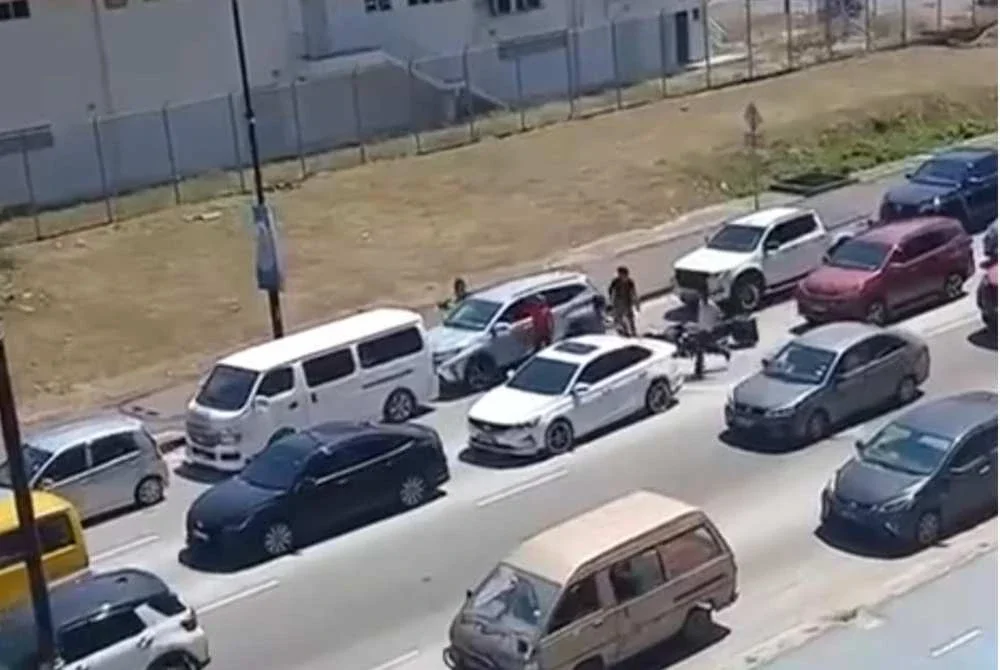 Tangkap layar video tular memaparkan sebuah kenderaan dikerumuni sekumpulan lelaki yang bertindak memukul cermin kereta di tepi jalan pusat bandar Kota Kinabalu.