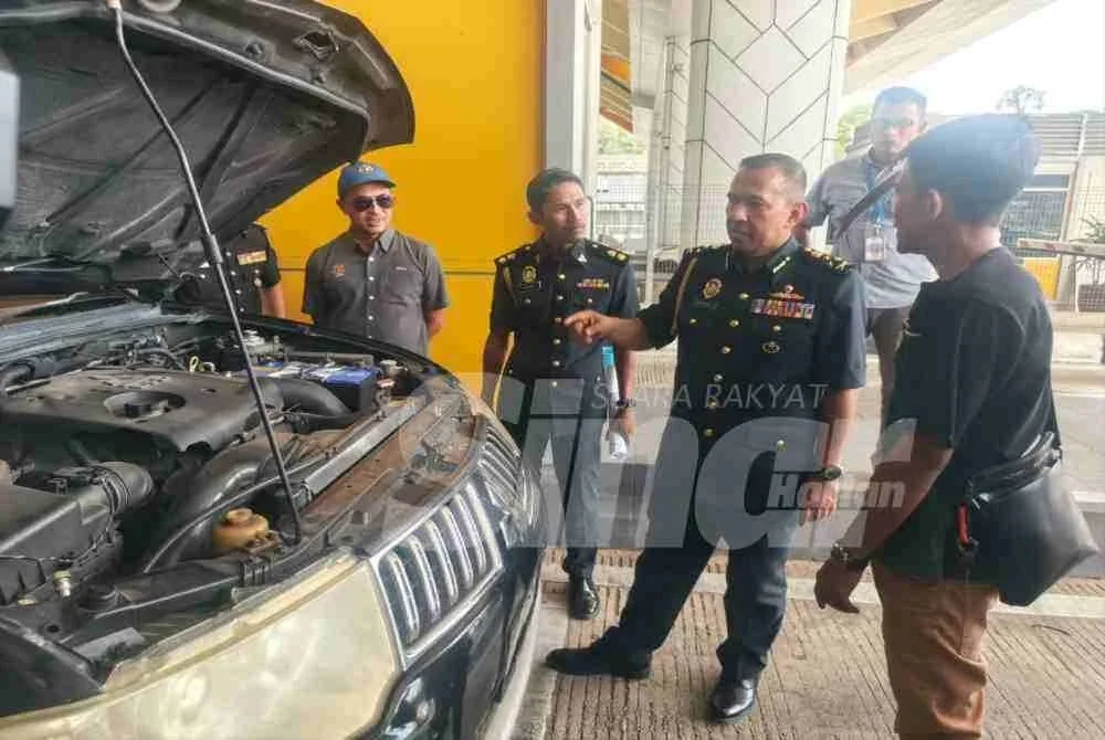 Shamsul Nizam (dua dari kanan) semasa membuat pemeriksaan terhadap sebuah kenderaan asing di Kompleks Imigresen, Kastam, Kuarantin dan Keselamatan (ICQS) Bukit Kayu Hitam, pada Ahad.