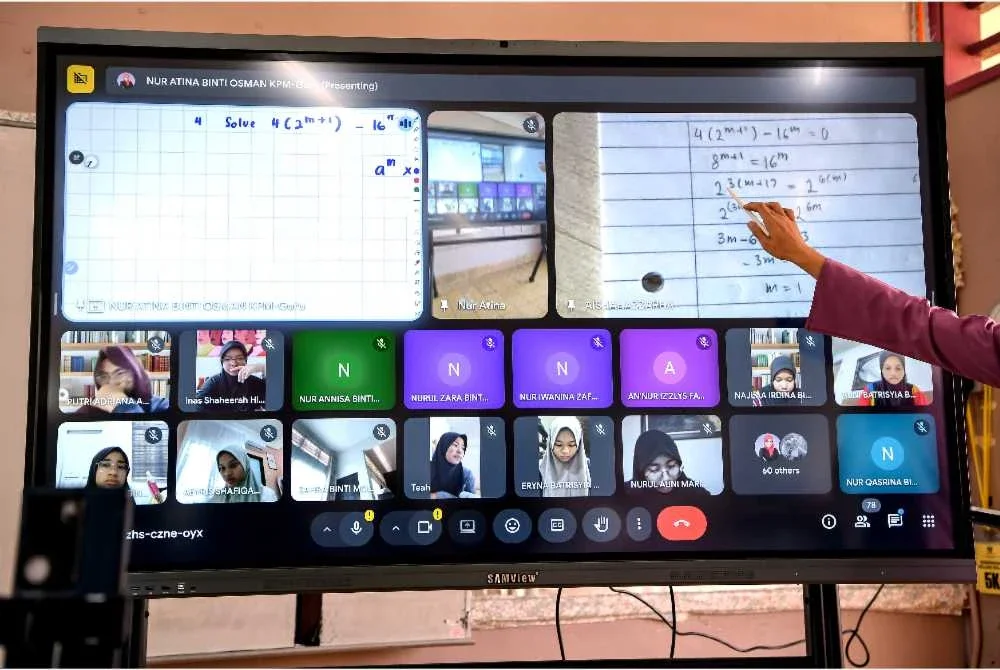 Guru Matematik Tambahan, Nur Atina Osman, sedang mengendalikan kelas hibrid melibatkan pelajar yang tinggal di asrama semasa sesi Pengajaran dan Pembelajaran di Rumah (PdPR) di Sekolah Menengah Kebangsaan (SMK) Sultanah Asma di sini. - Bernama