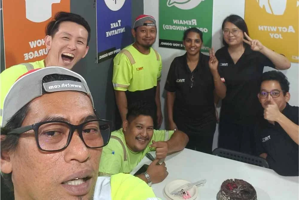 Illyasa (empat, kanan) bersama arwah (duduk, tengah) serta rakan-rakan sekerja.